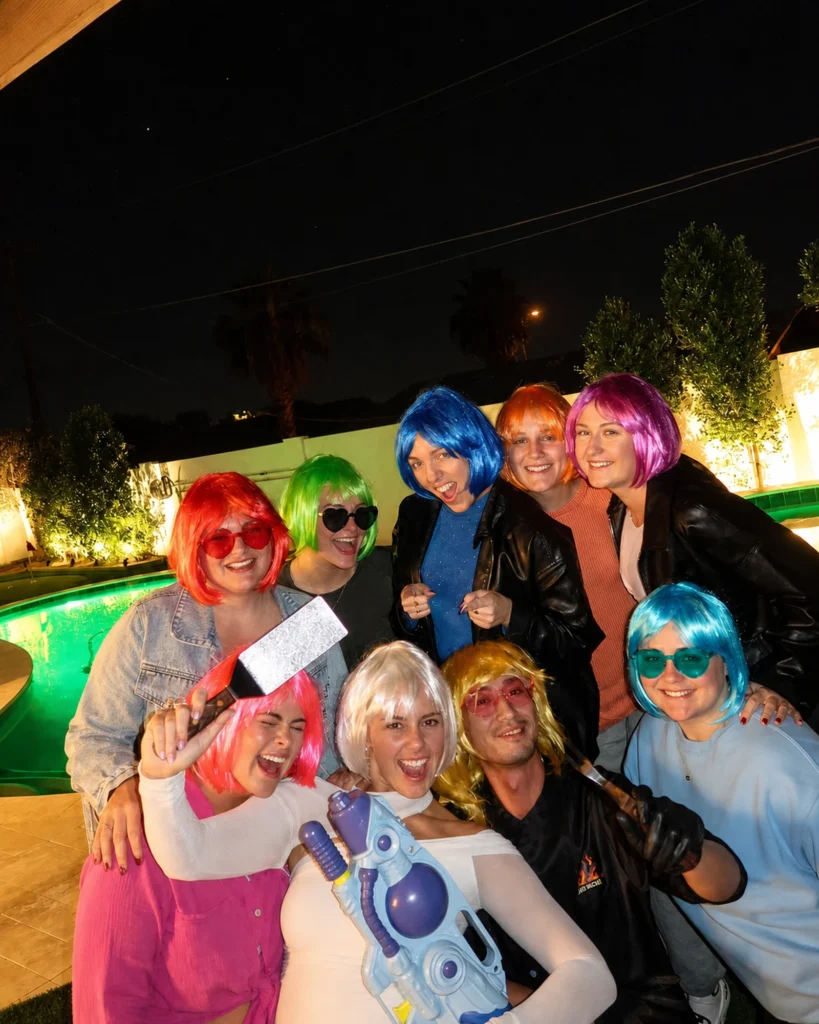 Guests wearing colorful wigs during a lively backyard hibachi party