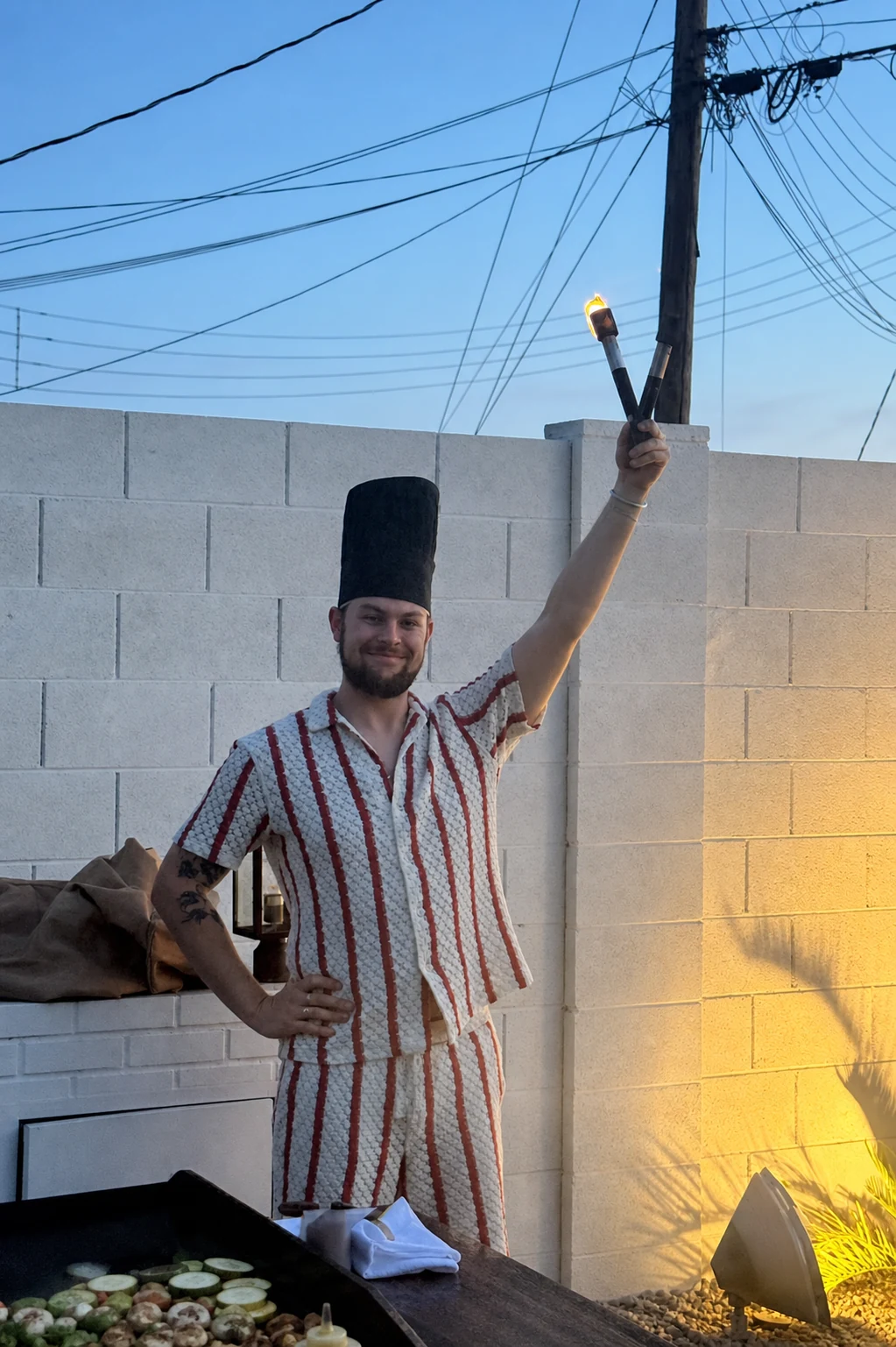 Private hibachi chef holding a flame torch beside the mobile grill