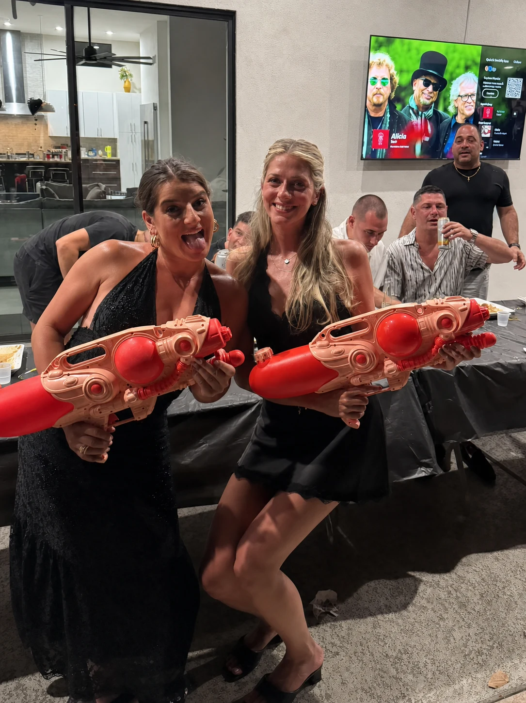 Friends laughing together during a hibachi water-gun game