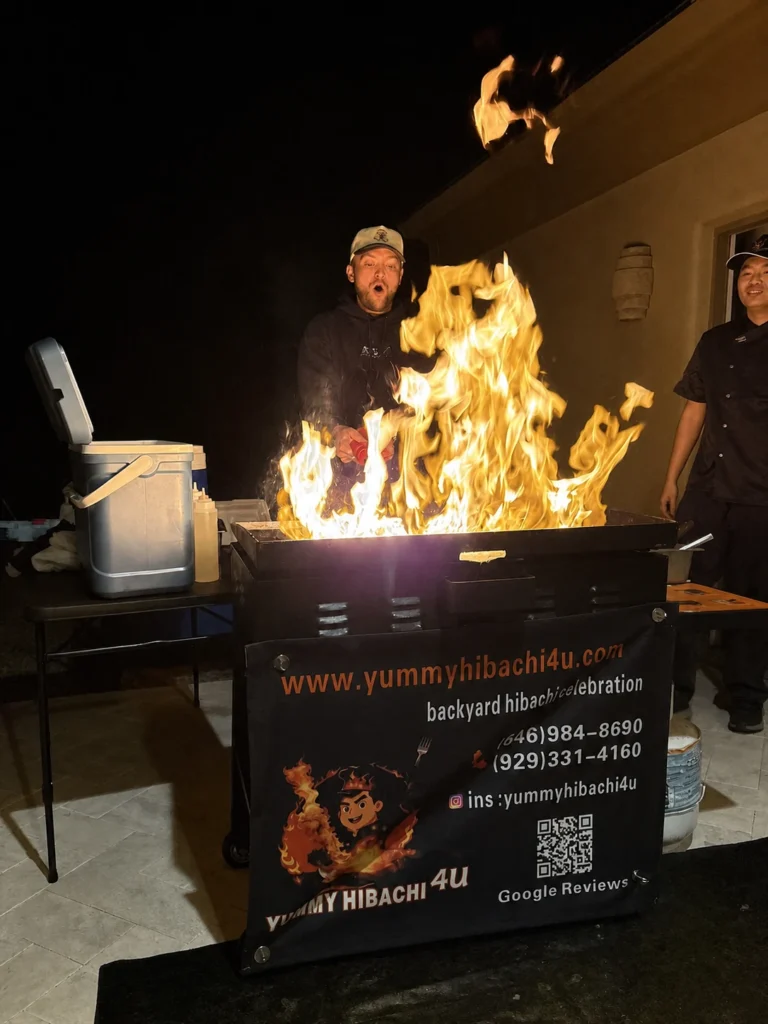 Hibachi chef creating a large flame over the mobile grill