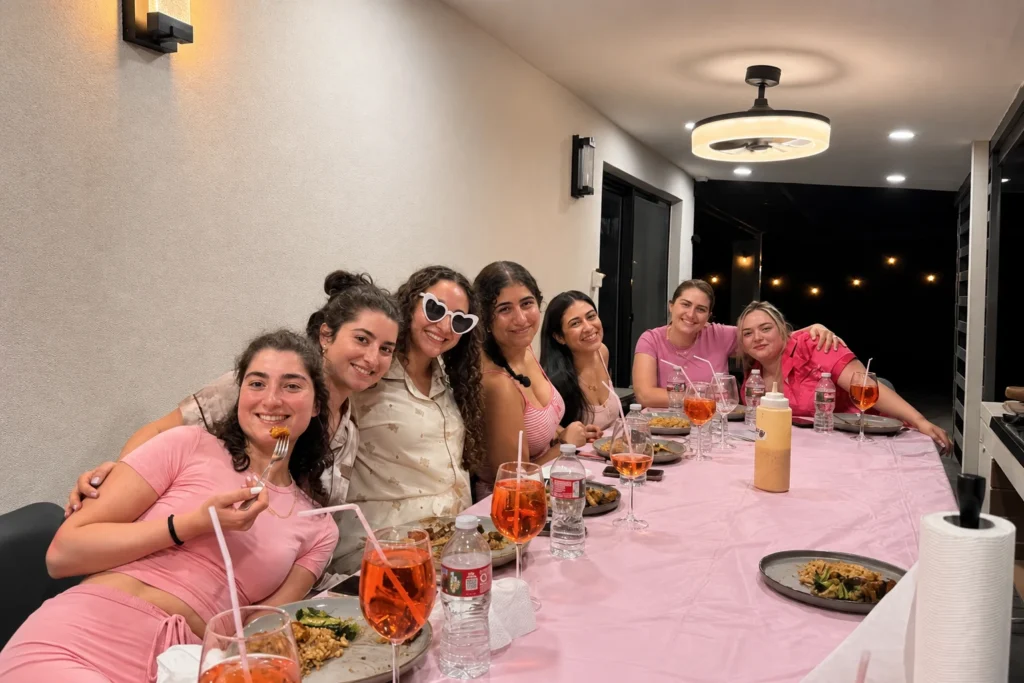 Friends dining around a pink table at a private hibachi party