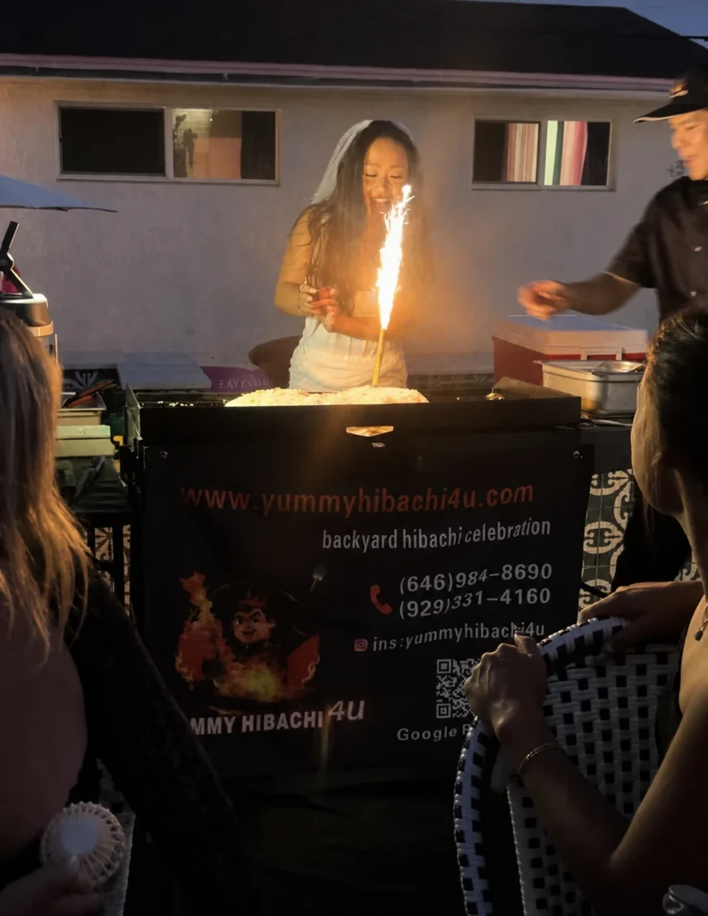 Guest taking part in a sparkler challenge beside the hibachi grill