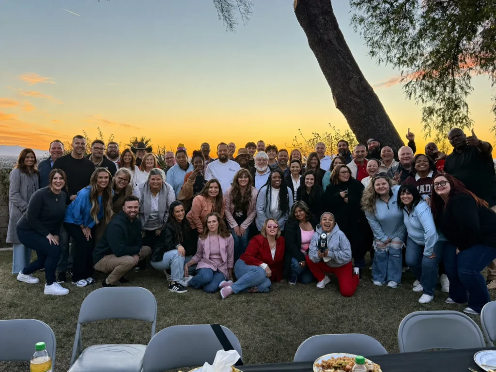 Large group posing together at sunset after a hibachi event